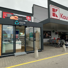 Elegantní modulární stánek IQOS s dřevěnými prvky, umístěný před hypermarketem Kaufland.